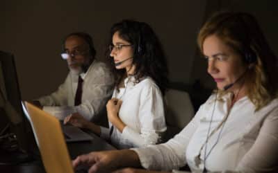 Profissionais de call center atendendo clientes com headsets em ambiente corporativo.