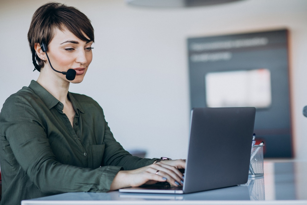 Atendente de call center trabalhando em laptop