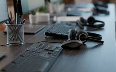 Mesa com teclados, mouses e fones de atendimento PABX.