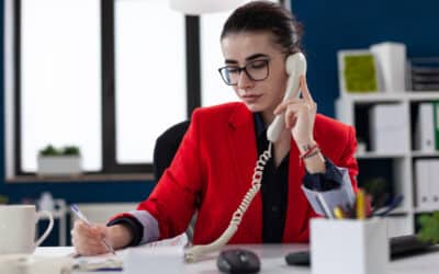 Agente de call center atendendo ao telefone e fazendo anotações. Mulher atendendo ao telefone e fazendo anotações.
