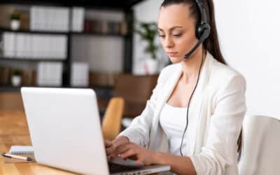 Atendente de call center utilizando headset enquanto realiza atendimento com serviço de callback em um notebook.