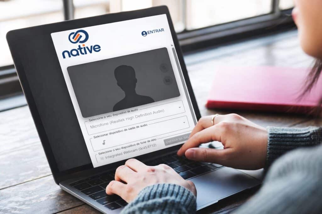 Tela de webconferência corporativa integrada exibida em notebook durante reunião online.