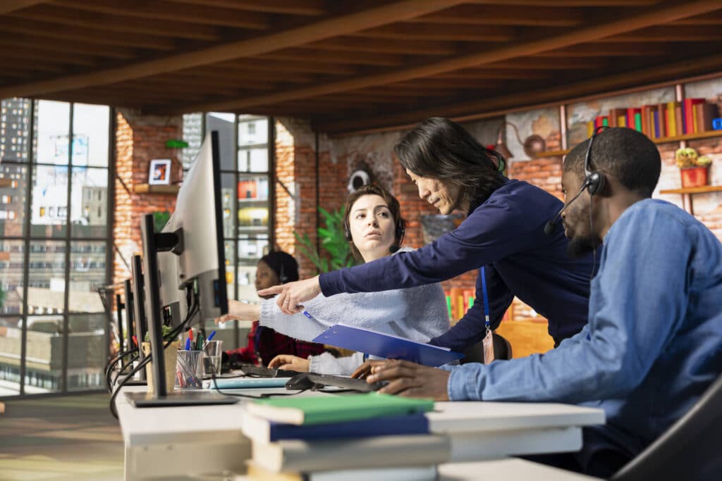 Equipe de atendimento receptivo analisando dados em central de atendimento