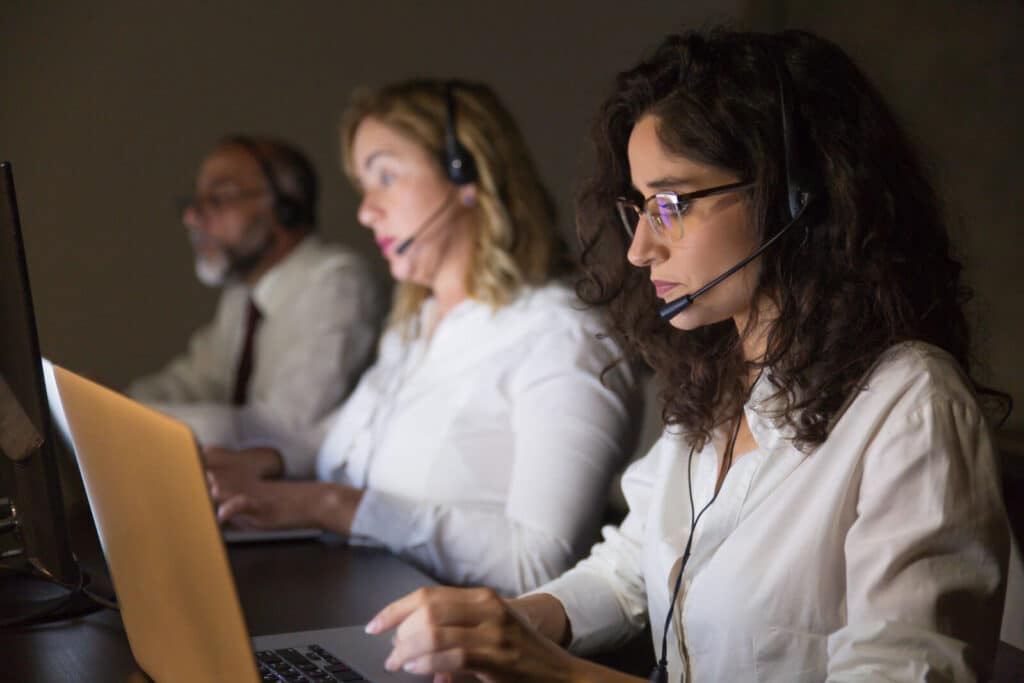 Operadores utilizando discador preditivo em operação de call center