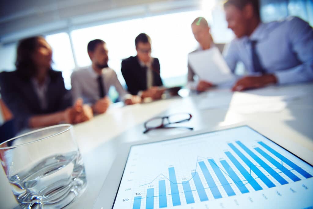 Equipe analisando indicadores de gestão financeira empresarial com apoio de telefonia PABX
