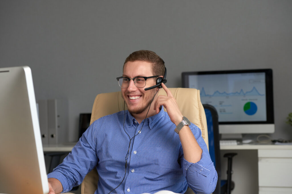 SDR realizando contatos comerciais com headset utilizando telefonia integrada para aumentar a produtividade da equipe de vendas