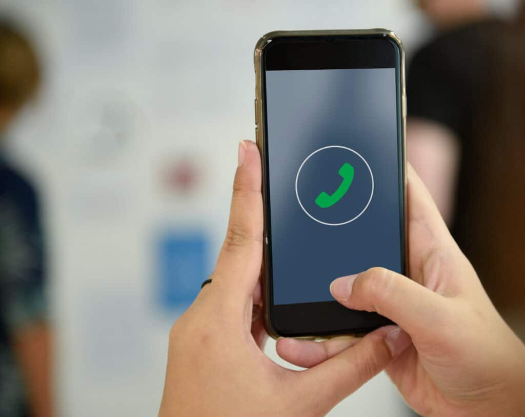 Pessoa utilizando um smartphone com identificador de chamadas durante uma ligação corporativa.