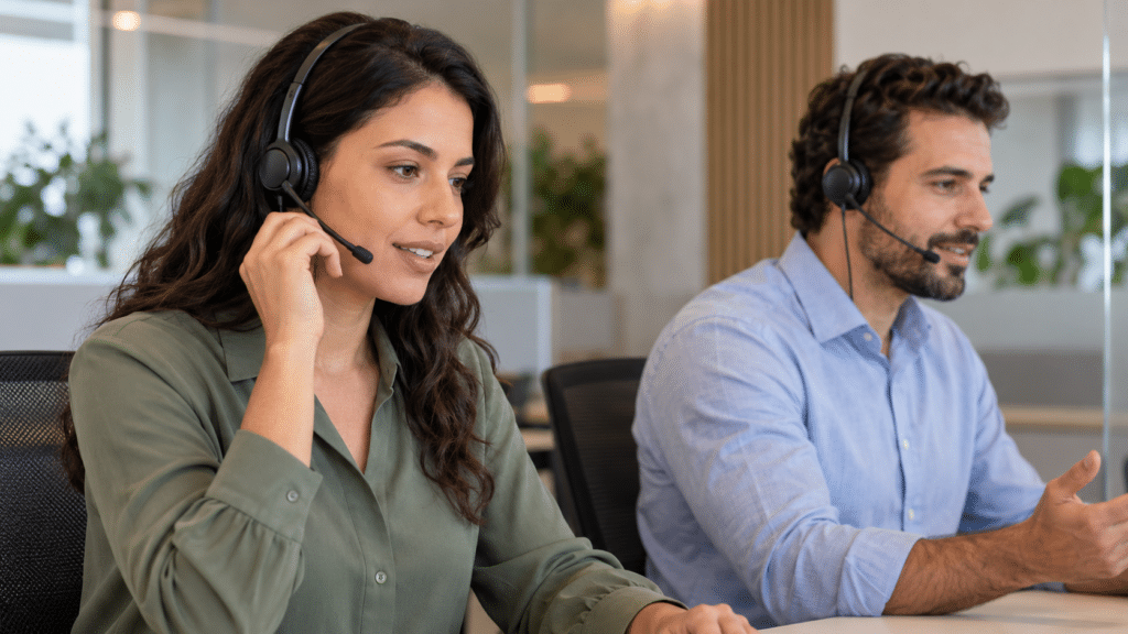 Dois profissionais com headsets em um call center, ilustrando o atendimento que apoia a tomada de decisão do cliente.